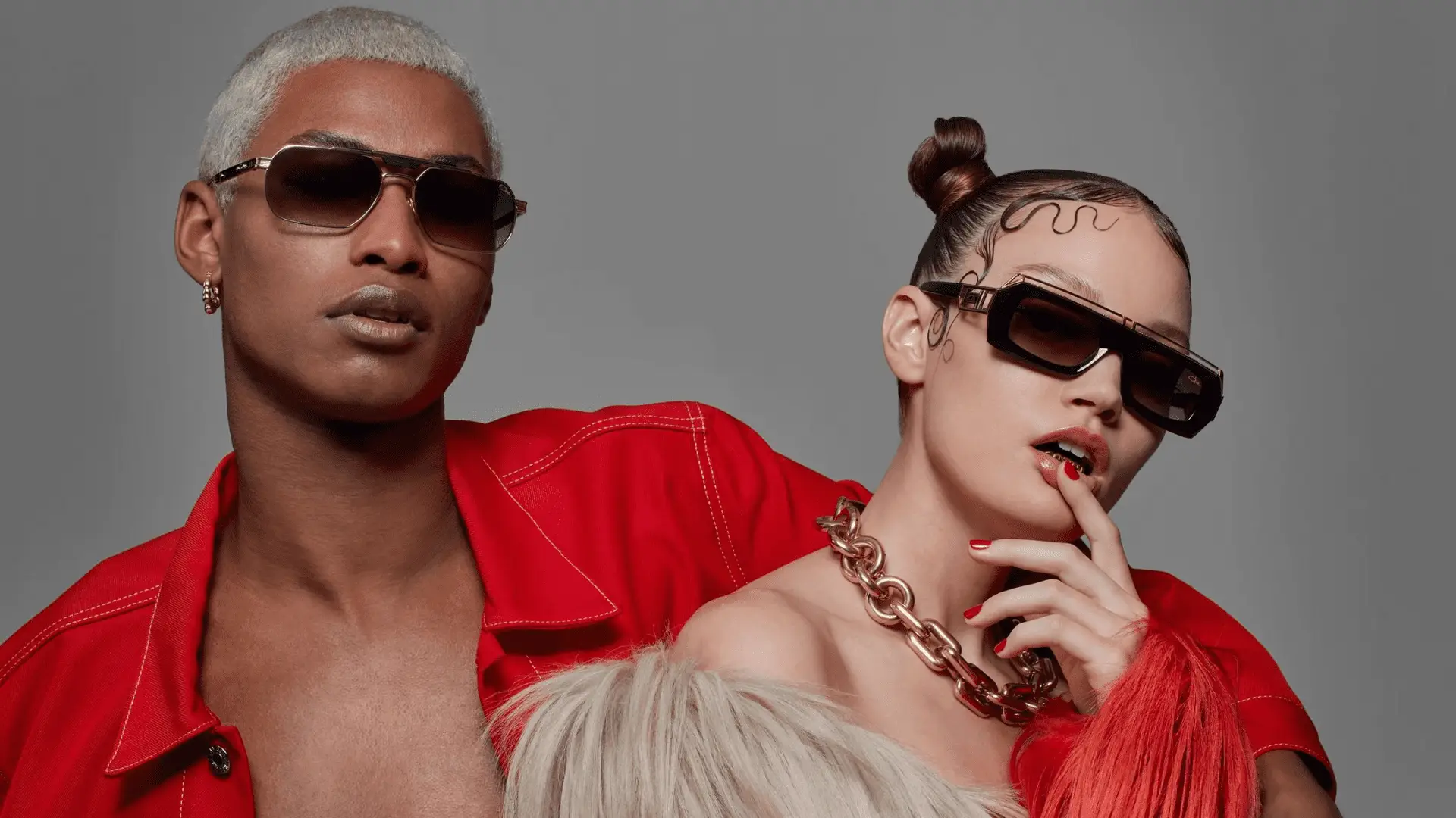 Zwei Models in roter Kleidung mit Sonnenbrillen.