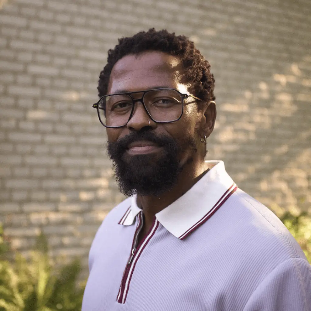 Mann mit Brille und Bart lächelt.