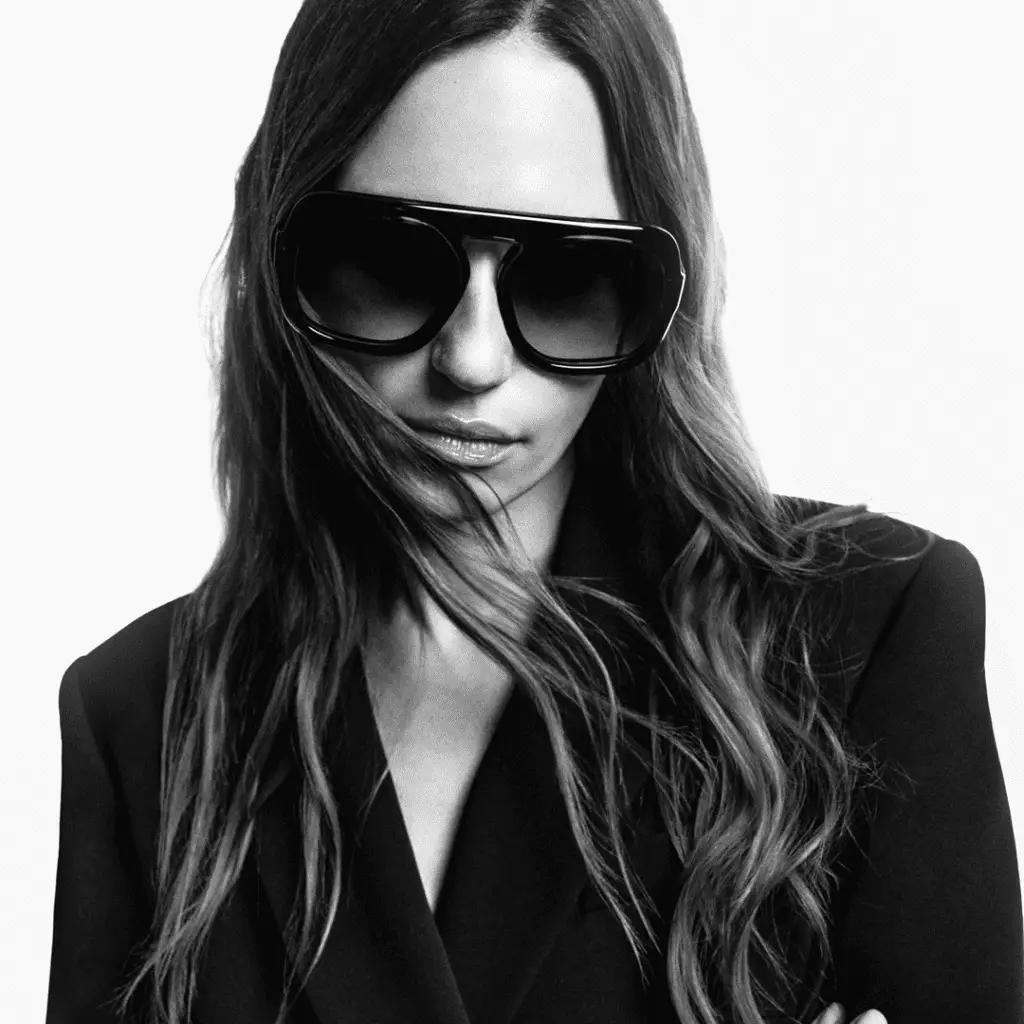 Frau mit Sonnenbrille von Emmanuelle Khanh und schwarzem Outfit.