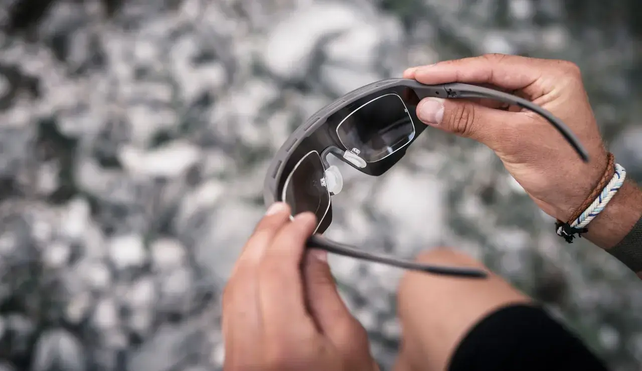 Person reinigt Sonnenbrille.