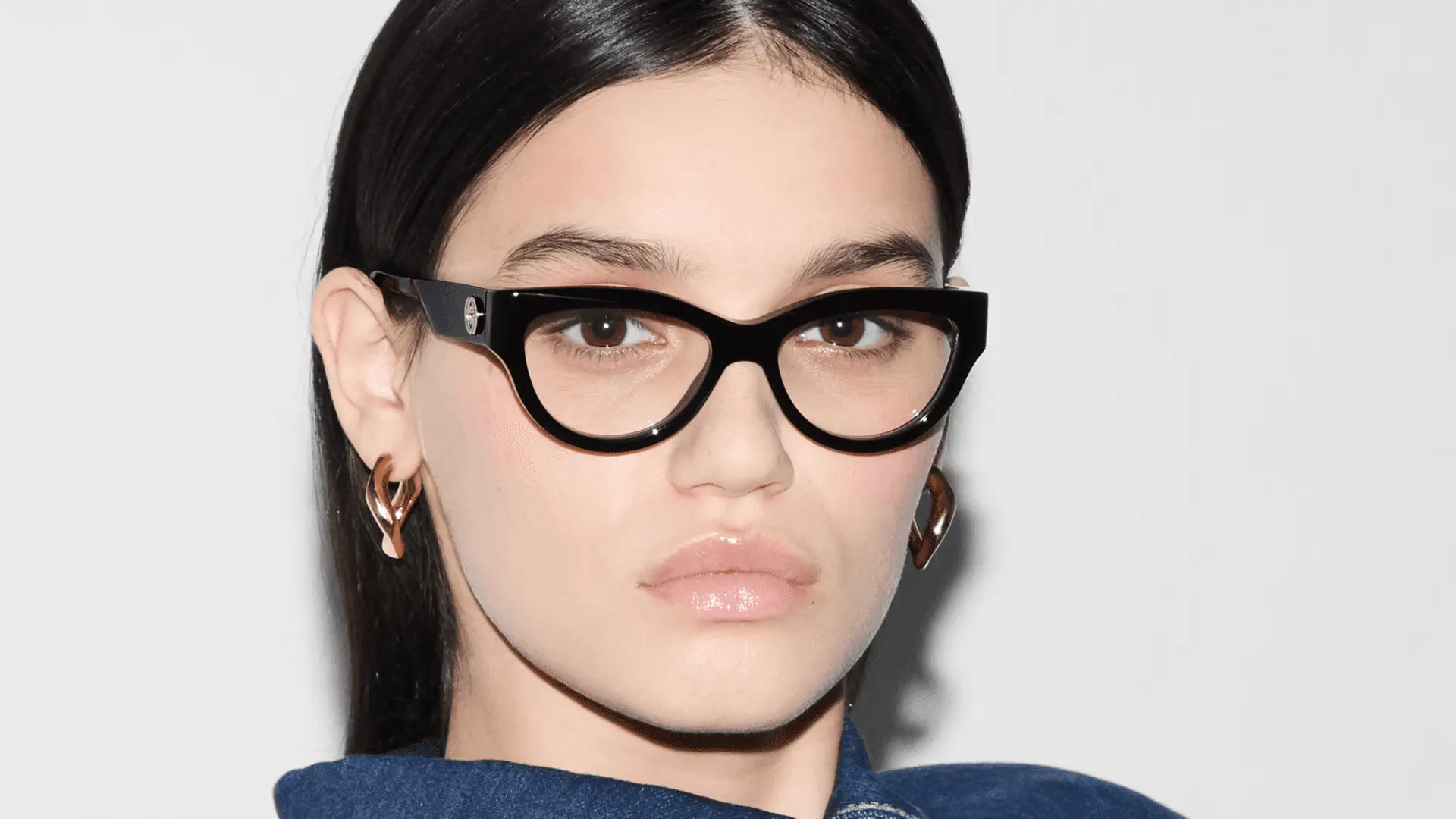 Frau mit Gucci Brille und Ohrringen.