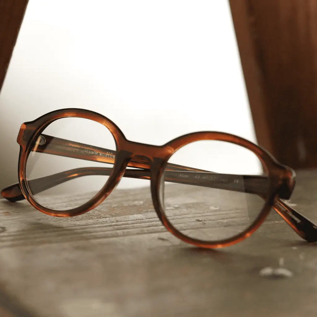Runde Brille von Hamburg Eyewear auf Holzoberfläche.